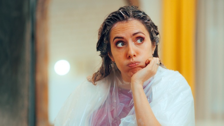 A woman who's frustrated with hair dye on her head