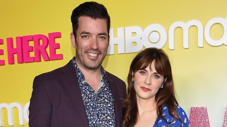 Zooey Deschanel and Jonathan Scott posing on a red carpet.