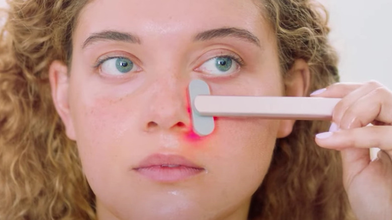 woman using red light wand