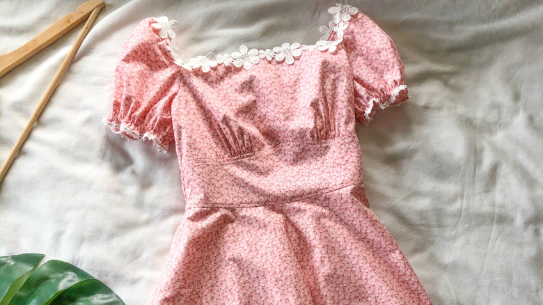 A pink dress with a floral lace neckline and Empire waist style