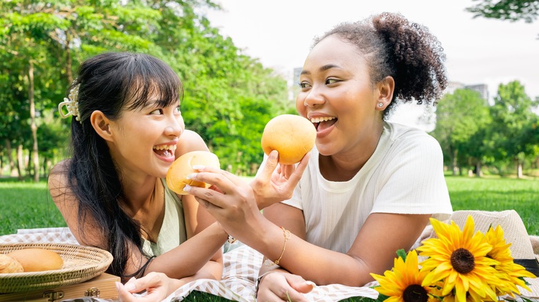Lesbian couple feeding each other rolls