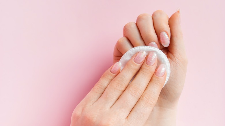 woman removing nail polish 