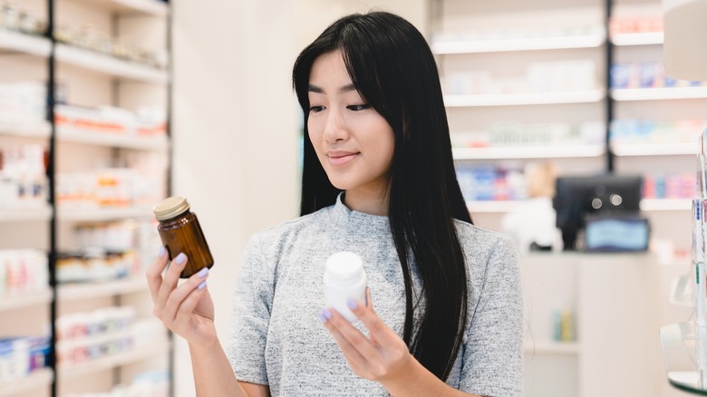 Woman comparing vitamins