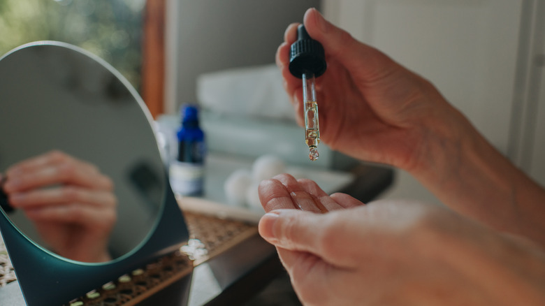 Person applying cuticle oil to nails