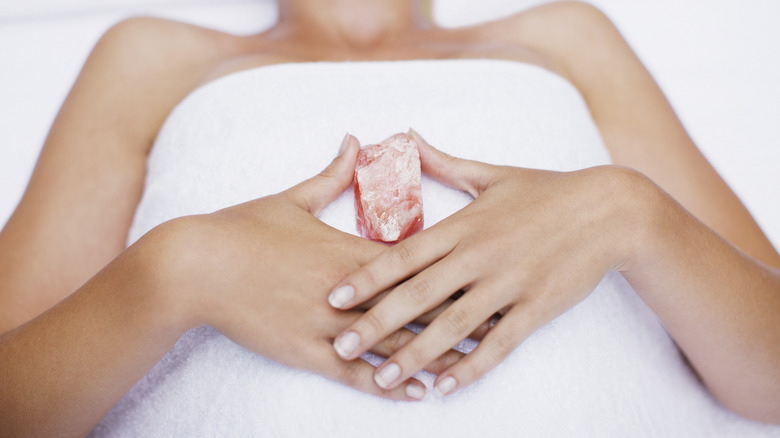 woman holding rose quartz on body