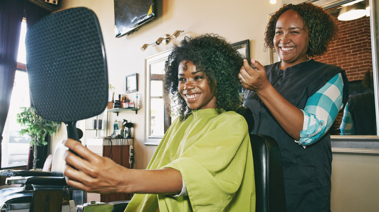 A client looking at themselves in the mirror at a hair salon.