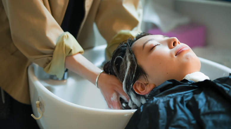 A person having their hair washed at the salon basin