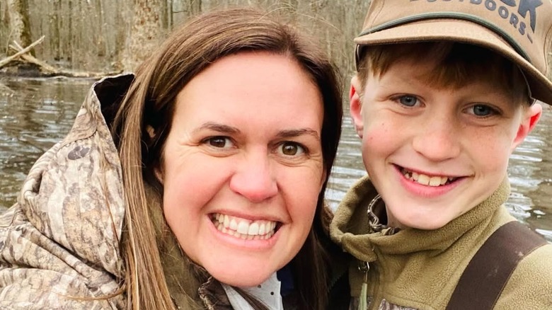 Sarah Huckabee Sanders poses with her son in the woods.