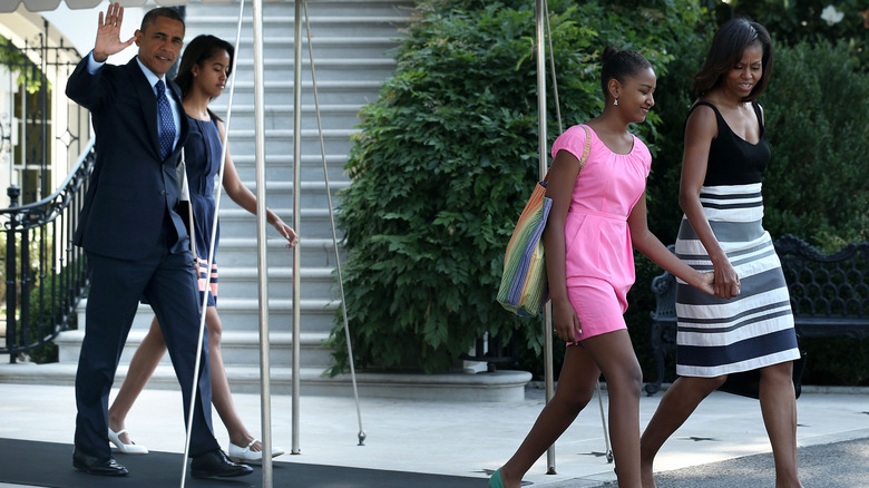 The Obamas leaving for Africa, with Sasha wearing a pink dress