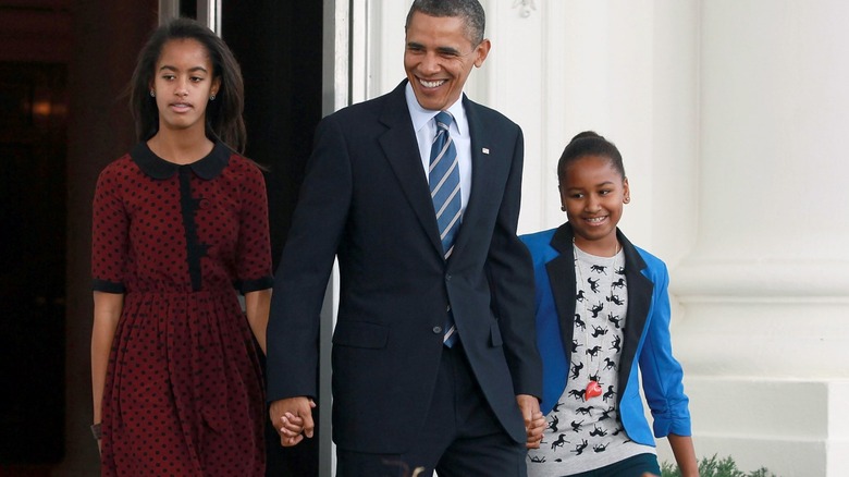 Sasha Obama walking with Malia and Barack Obama at the White House