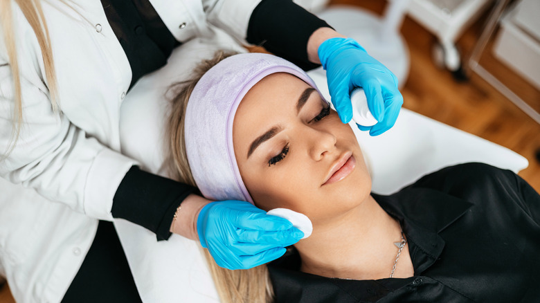 esthetician offering treatment to client