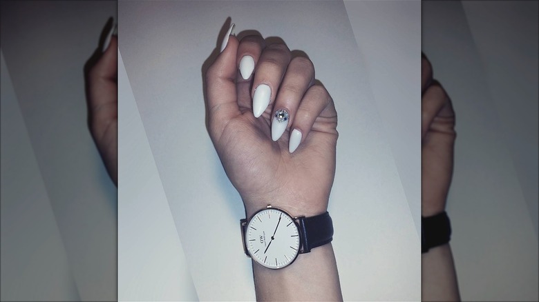 hand with white shimmer stiletto nails