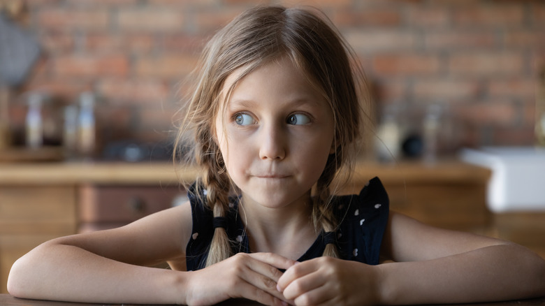 long-haired child looks askance
