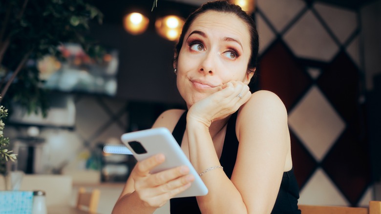 Woman looking up from her phone