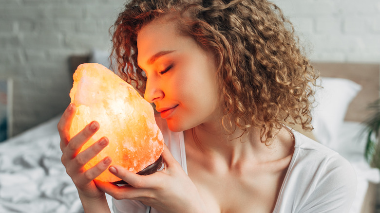 Smiling woman holding salt lamp