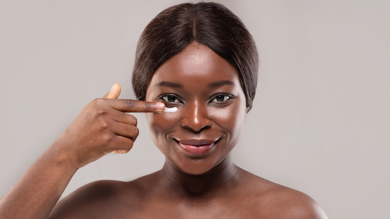 woman applying under eye cream