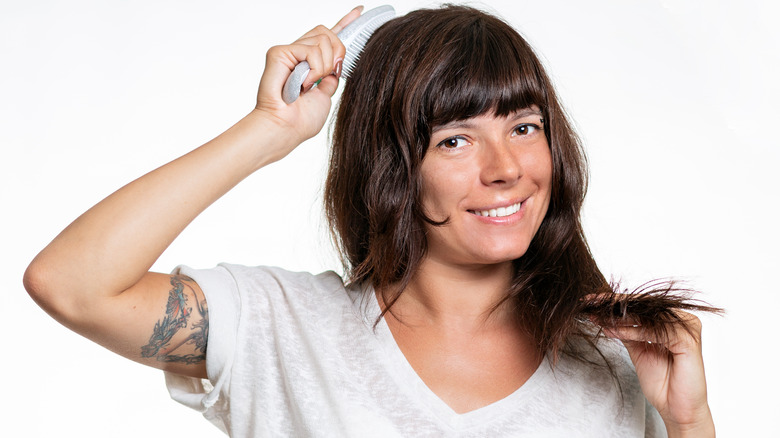 woman smiling brushing shiny hair
