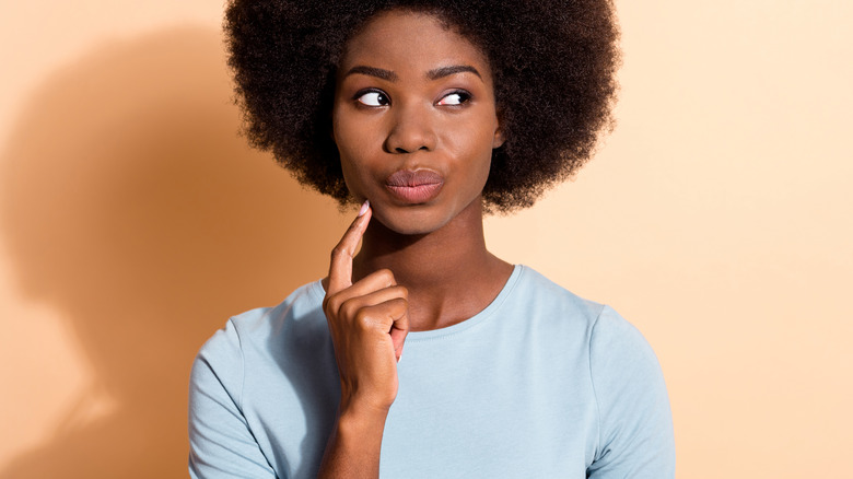 woman thinking finger to her chin