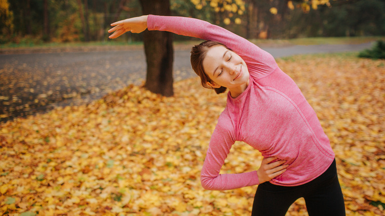 woman stretching in park 