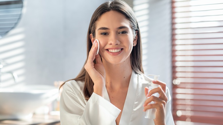 woman removing makeup with cotton round