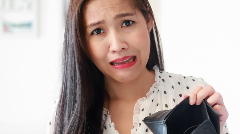 sad shopper holding empty purse
