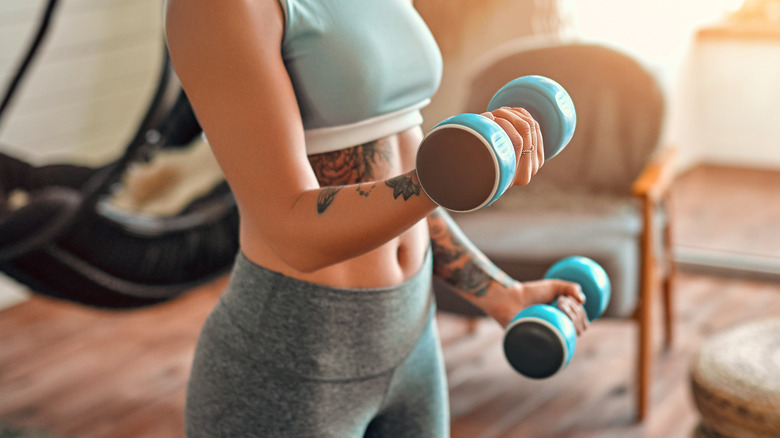 Tattooed woman lifting dumbells