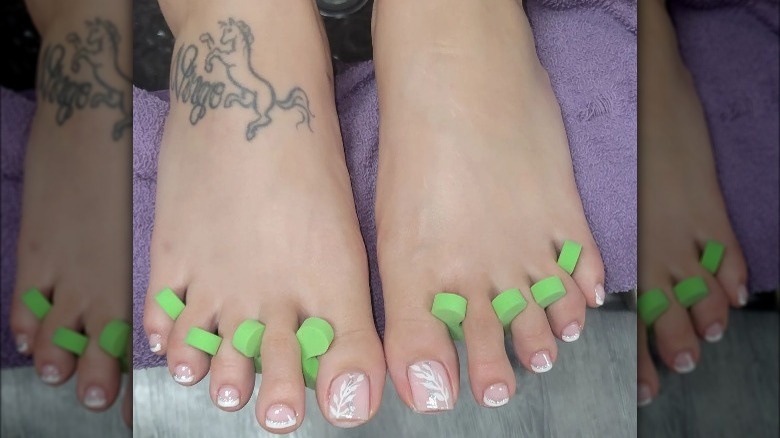 French pedicure with floral design and glitter