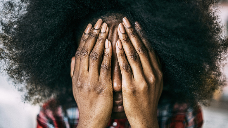 woman with hands over face