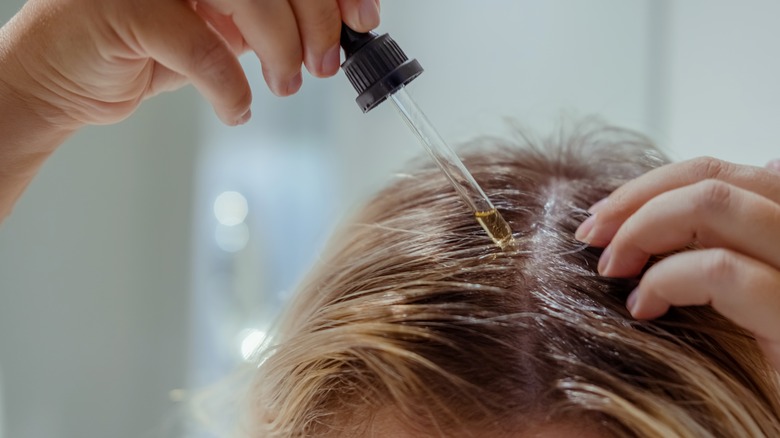 woman applying oil to scalp