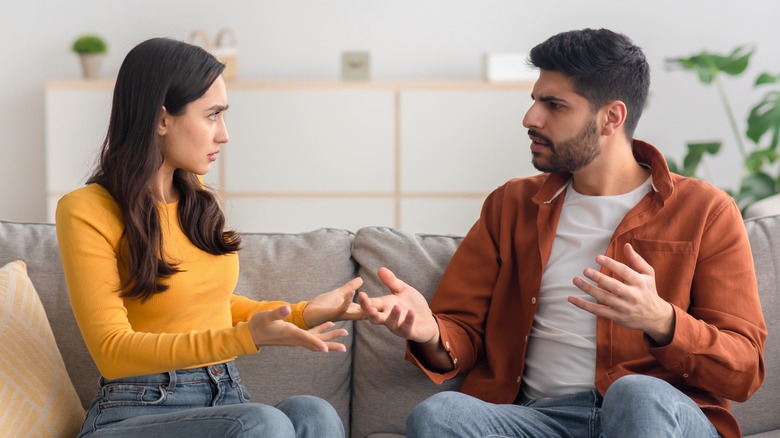 couple sitting on couch arguing