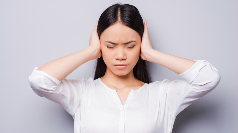 Woman covering her ears