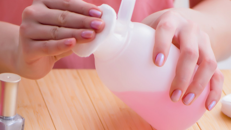 woman holding nail polish remover
