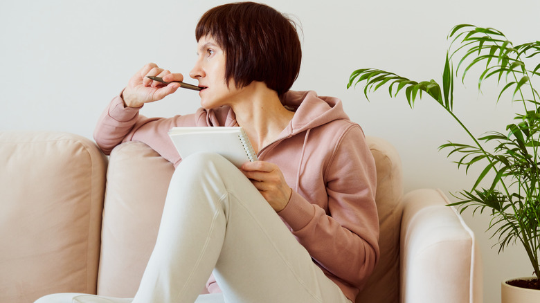 Woman sitting with pen, notebook