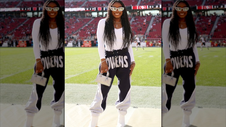 Simone Biles wearing white boots with sweatpants at a Bears game