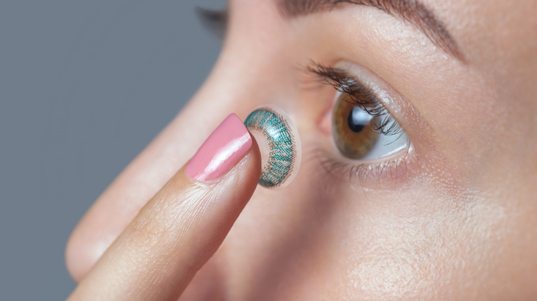 Person putting in colored contacts