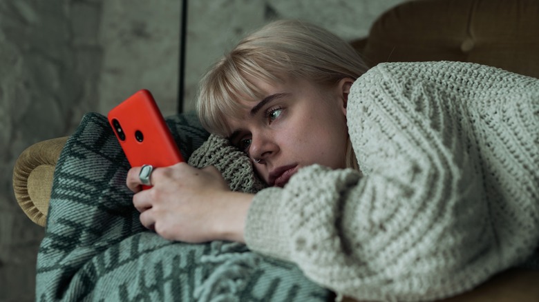 tired woman looking at phone