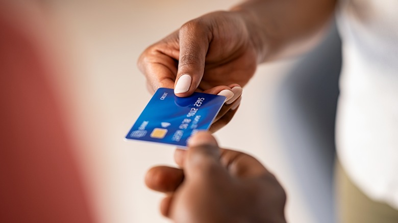 Two people holding a credit card