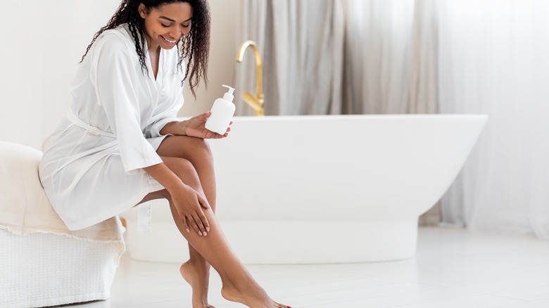 Woman applies moisturizer 