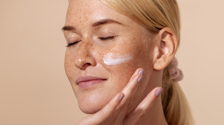 woman applying mosturizer