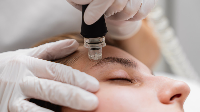 A woman getting a microdermabrasion treatment.