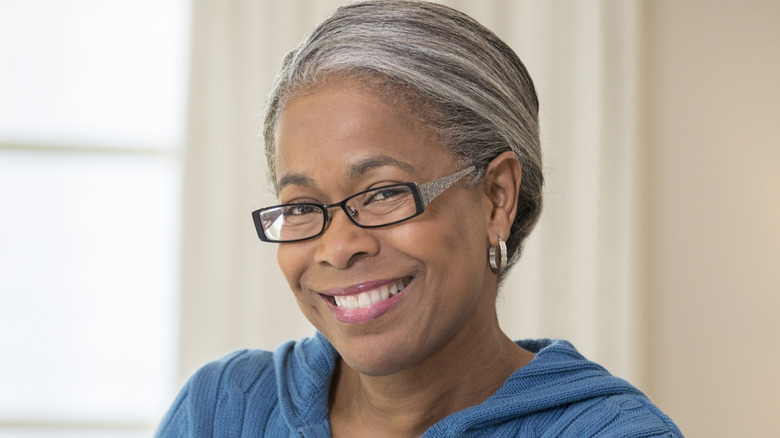 A mature woman wearing narrow eyeglasses.