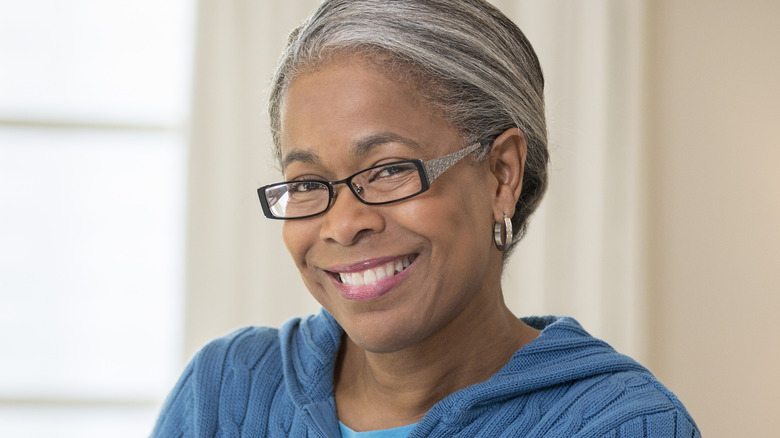 A mature woman wearing narrow eyeglasses.