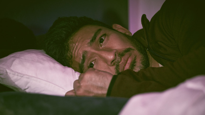 man sleepless in bed