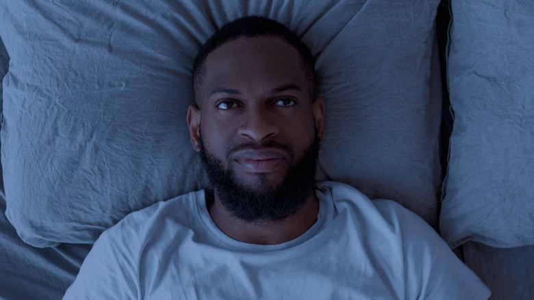 sleepless man awake in bed