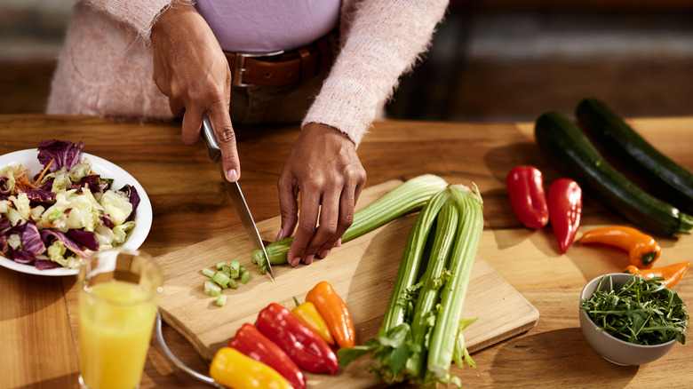 Woman cutting vegetables in kitchen