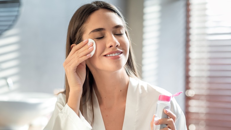 Woman applying skincare product to her face