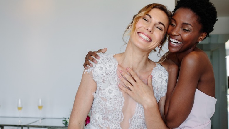 Bride and bridesmaid hugging 