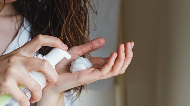 A woman applying hair product