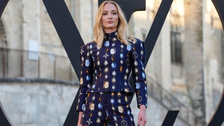 Sophie Turner in a navy jacket and shorts