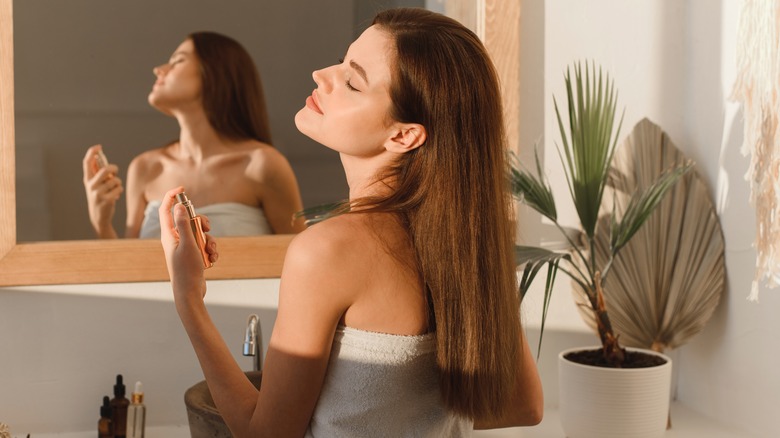 Woman spraying on perfume